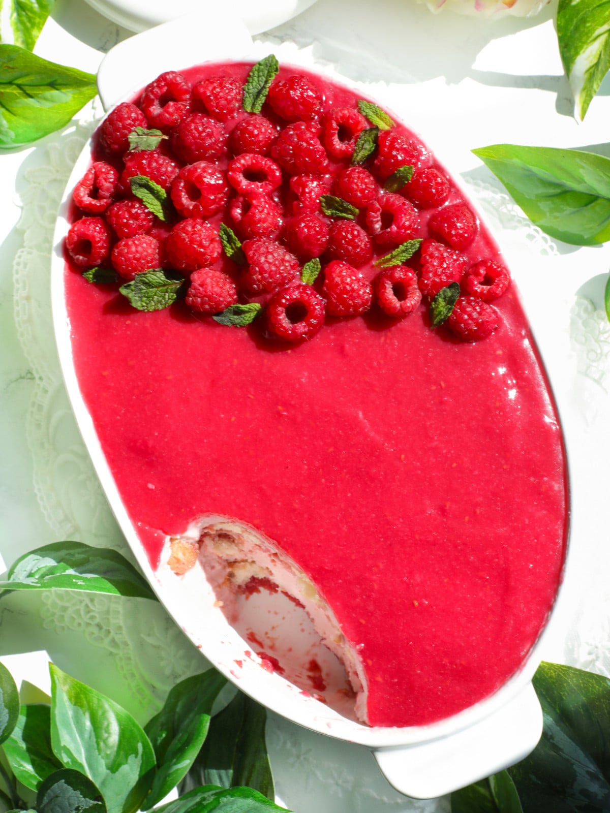 Egg free raspberries tiramisu in a white oval dish.