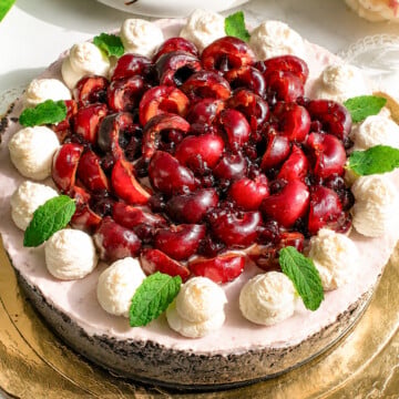 Cherries cheesecake on a golden board.