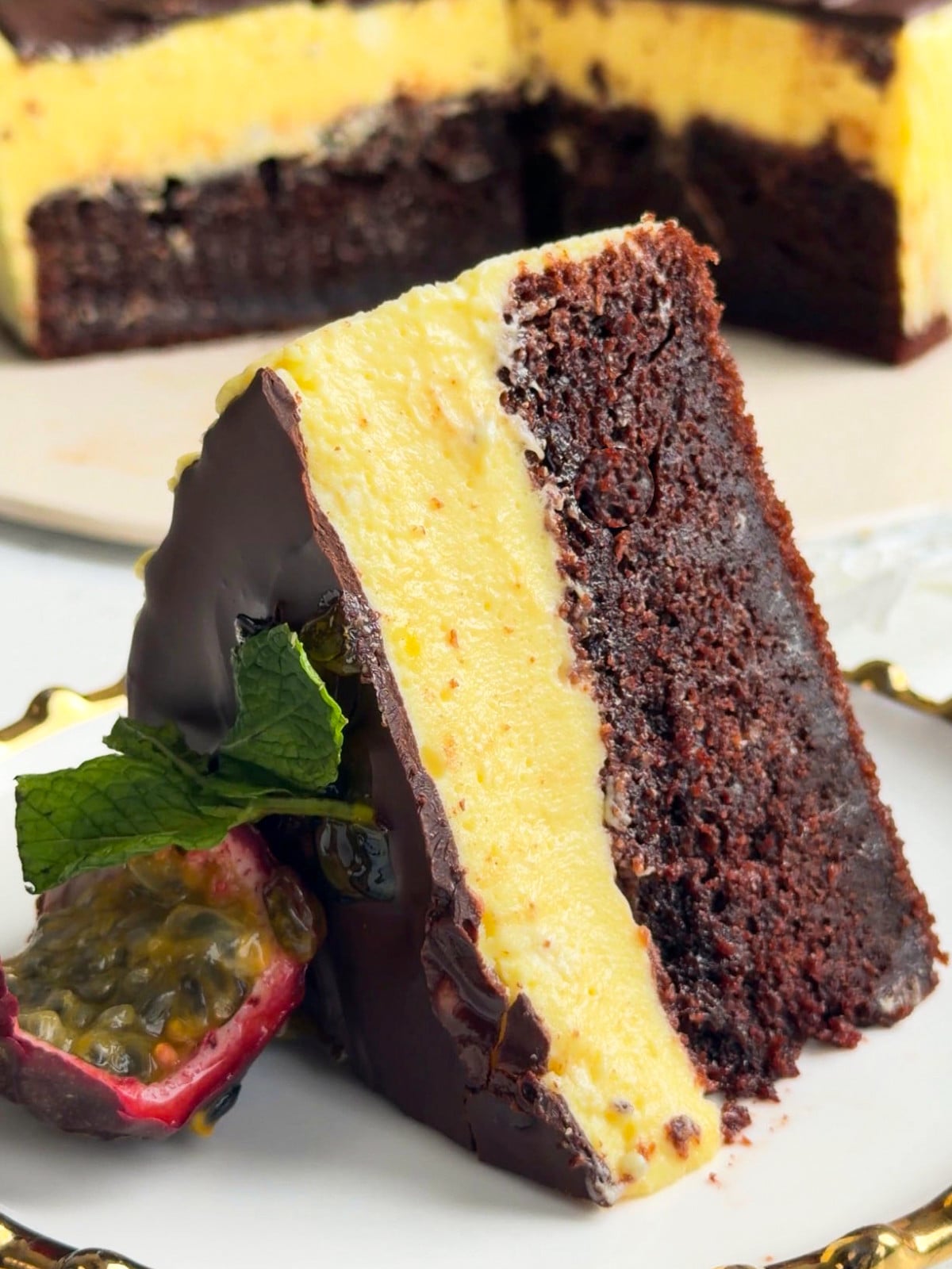 A slice of passionfruit and chocolate cake on a plate.
