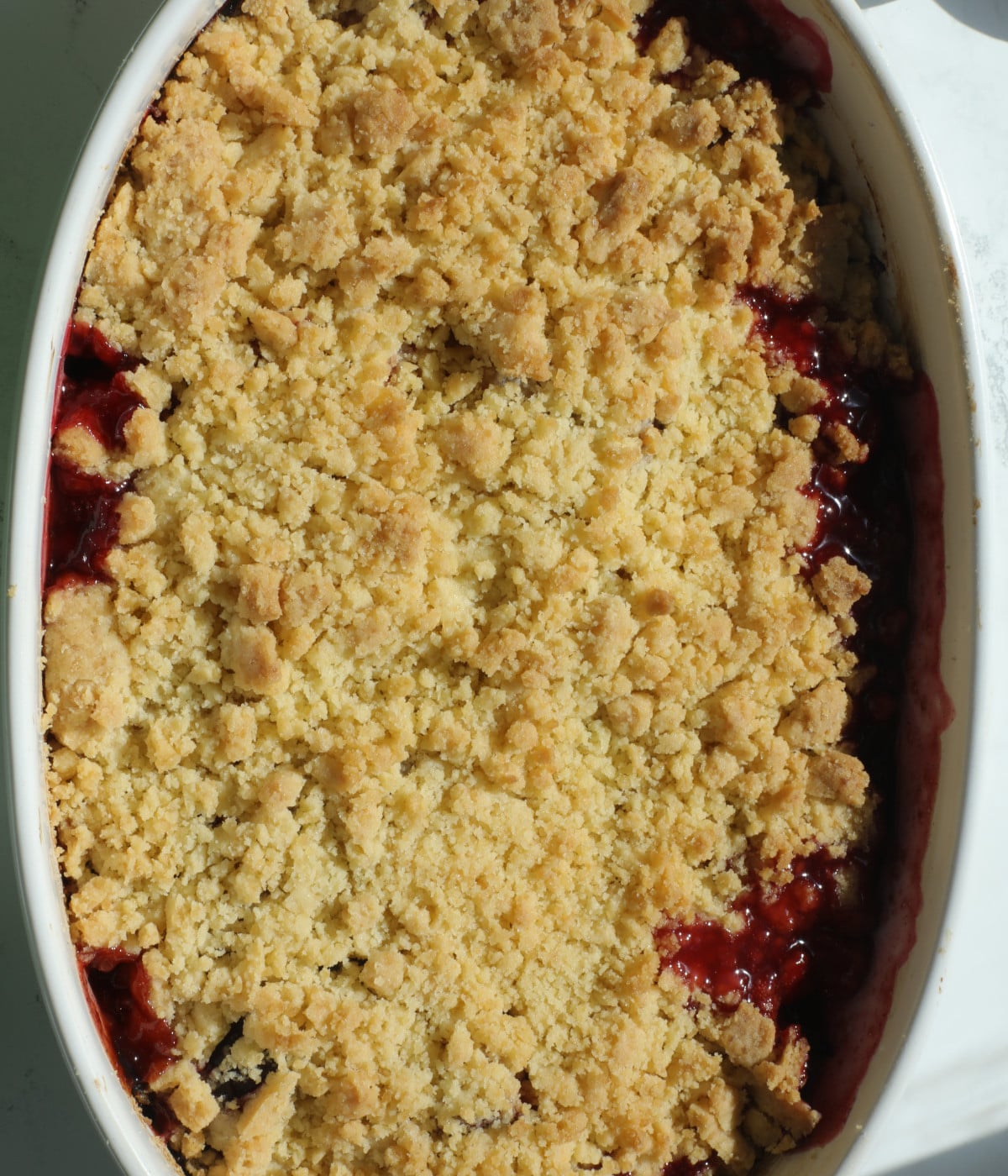 Baked plummed crumble in a white dish.