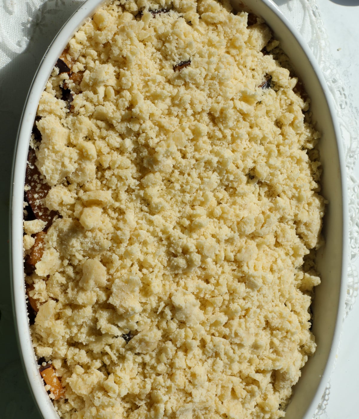 Blitzed crumble on top of sliced plums.