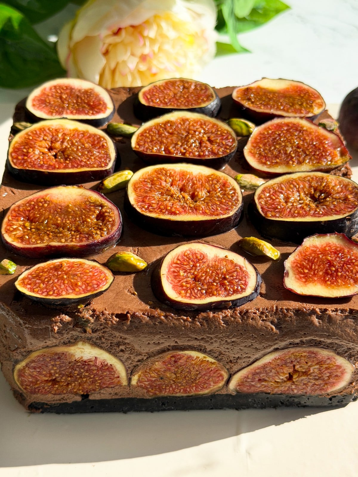 Chocolate mousse with fig slices on a beige board.