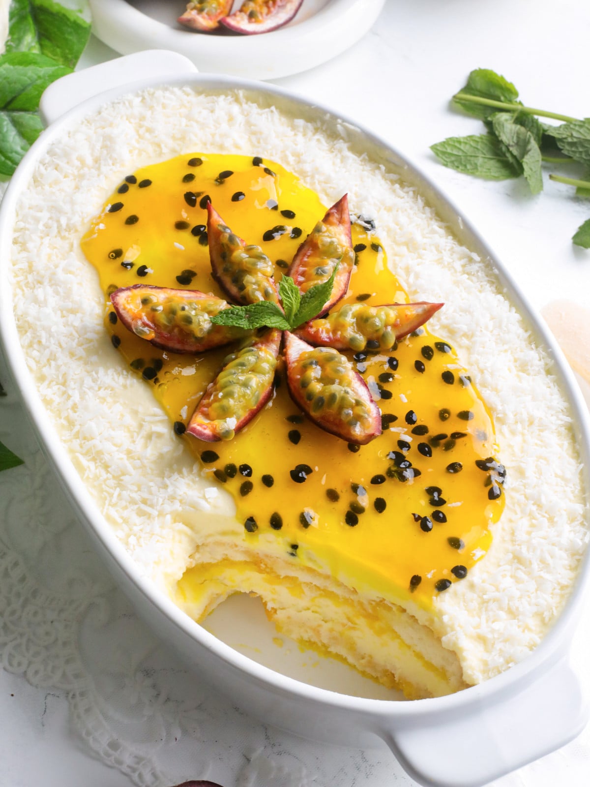 Passion fruit coconut tiramisu in a white dish.
