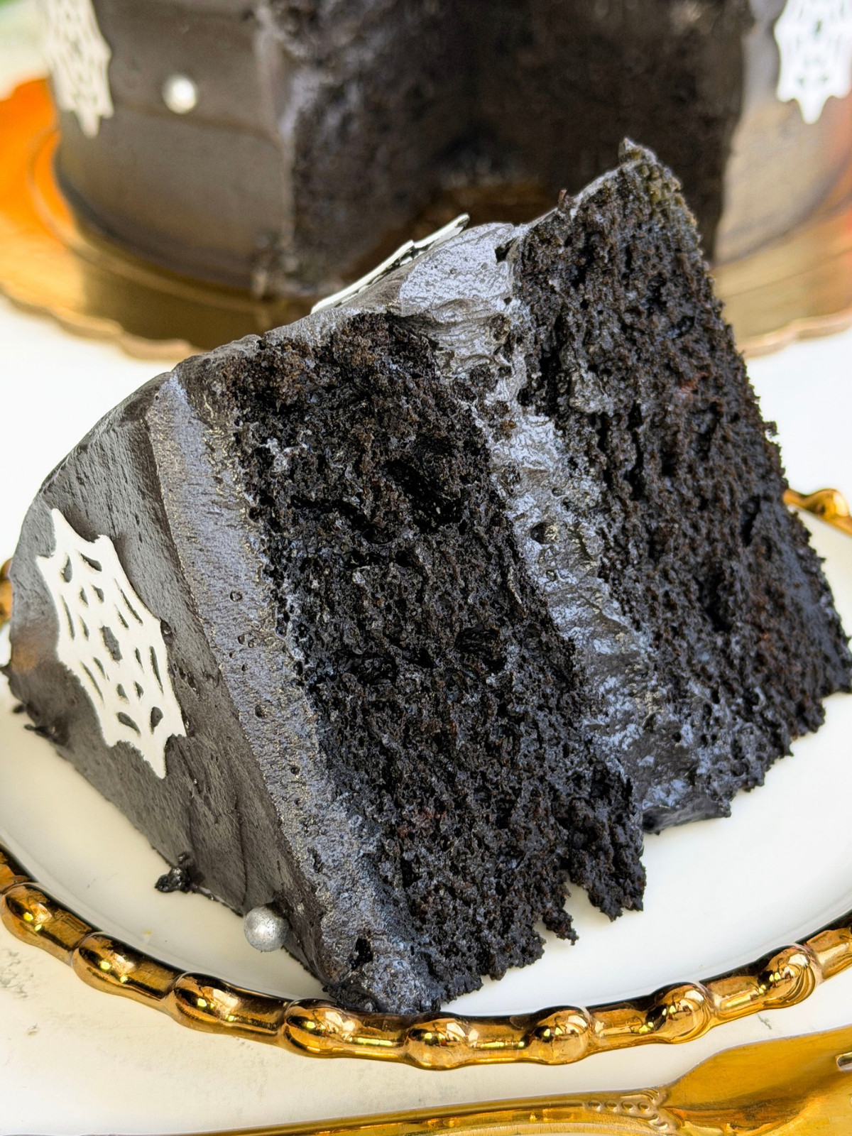 Black cake on a gold plate.